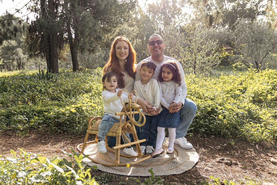 משפחה עם סוס נדנדה מקש על הדשא ביער
